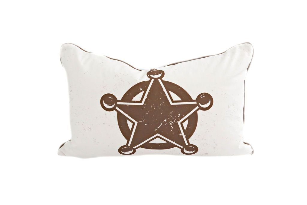 A white lumbar pillow with a brown sheriff badge design. 