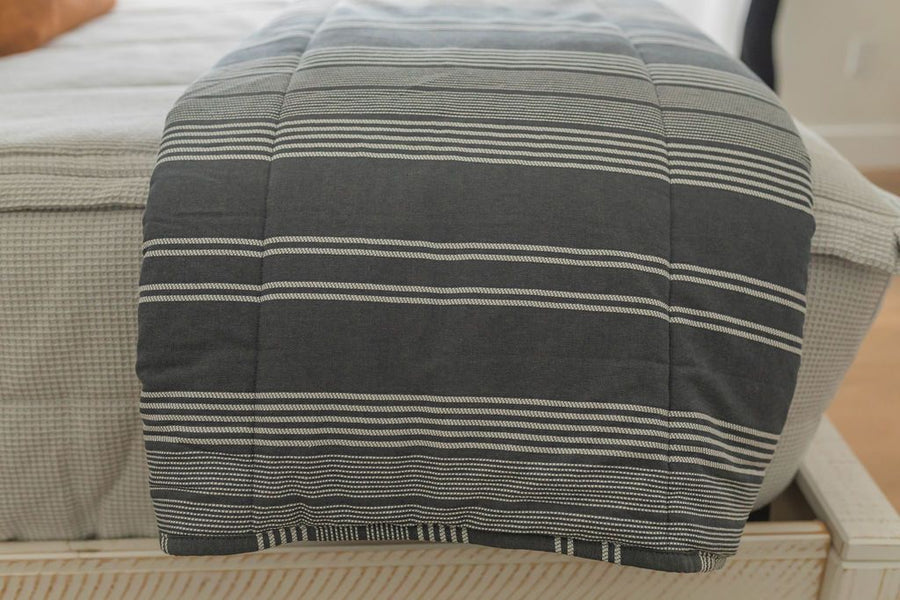 Gray blanket with white stitching on gray zipper bedding