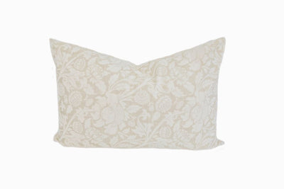 A tan and cream floral design pillow on a white background.