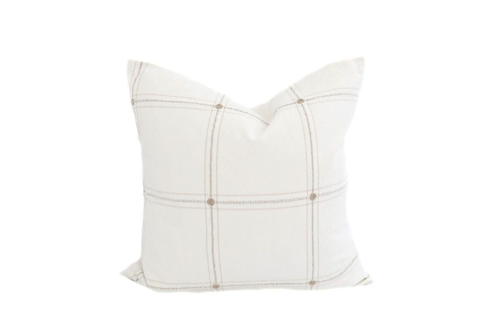 A white medium pillow with a cream plaid embroidery design.