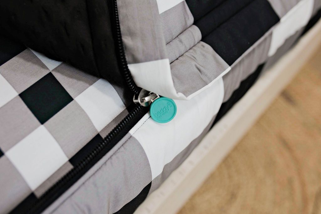 photo showing zipper edge on white and black buffalo plaid bedding, white and black plaid sheets and black minky interior