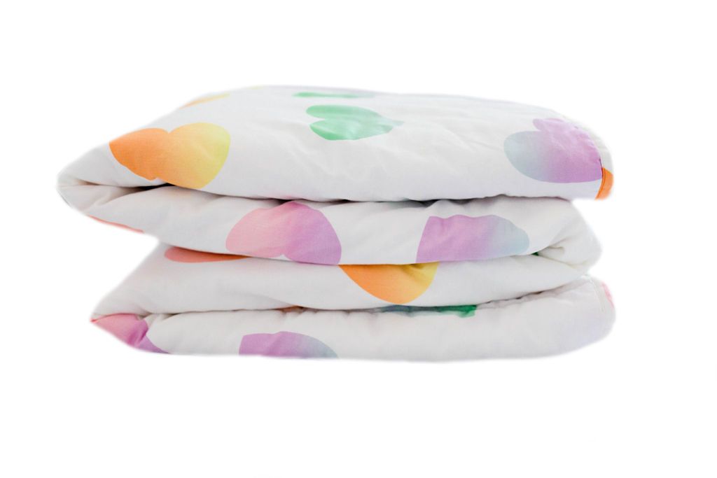 folded white blanket with ombre rainbow hearts