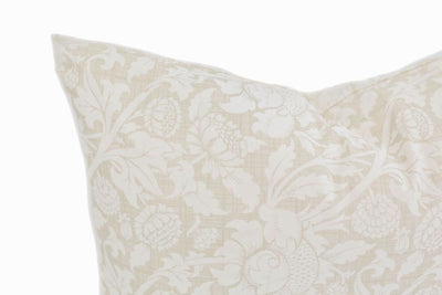 Close up of White and cream lumbar pillow with floral design 