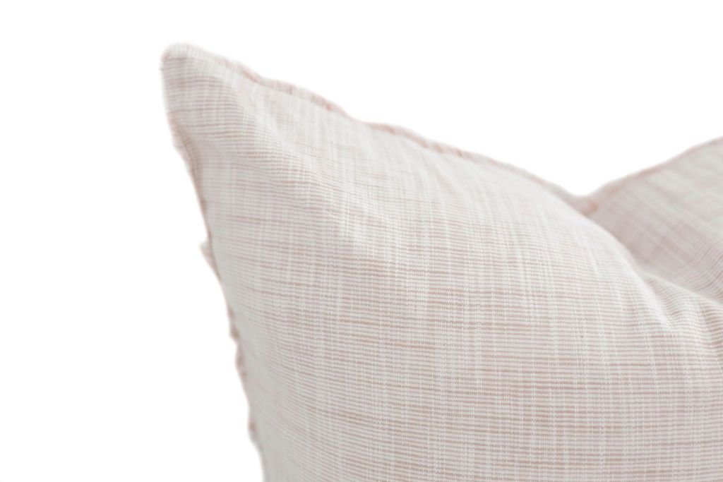 Close up of white and light pink decorative pillow