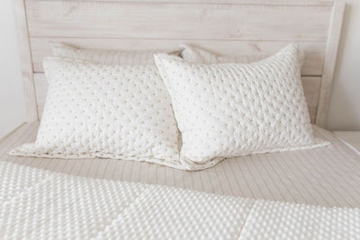 White and cream sham with brown stitching on matching zipper bedding