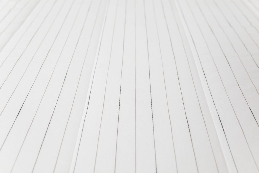 A close up view of the pinstriped textured design on a white zipper bedding.