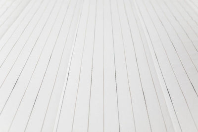 A close up view of the pinstriped textured design on a white zipper bedding.