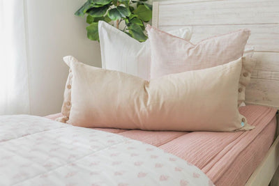 Pink zipper bedding with white, pink and cream pillows and white blanket
