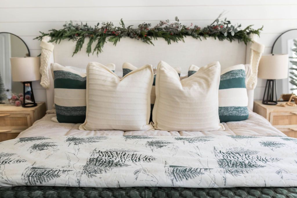 Tan zipper bedding styled with white, tan, cream and green pillows and green and white blanket