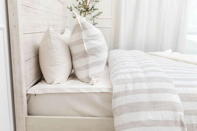 Ivory sheet set styled with matching white pillows and duvet bedding