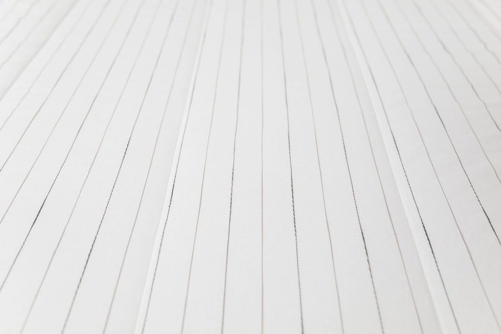Close up of white zipper bedding with pin stripe design