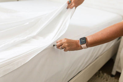 A close up view of a person zipping up a white zipper sheet set.